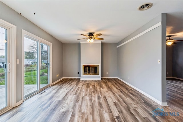 unfurnished living room with hardwood / wood-style flooring and ceiling fan