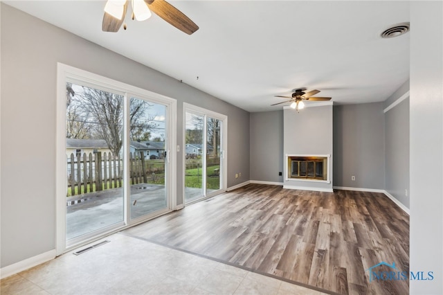 unfurnished living room featuring light wood-type flooring and ceiling fan