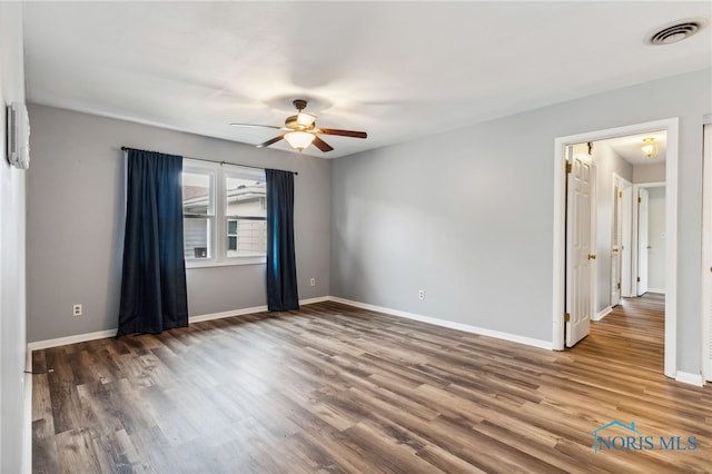 unfurnished room with dark wood-type flooring and ceiling fan