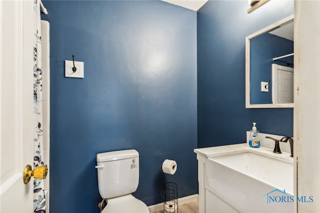 bathroom featuring toilet, vanity, and hardwood / wood-style floors