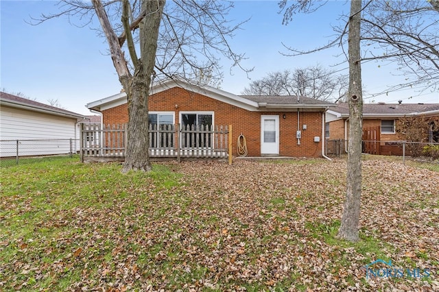 back of property with a wooden deck and a yard