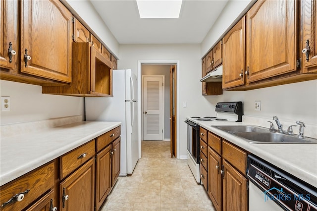 kitchen featuring a skylight, white appliances, and sink