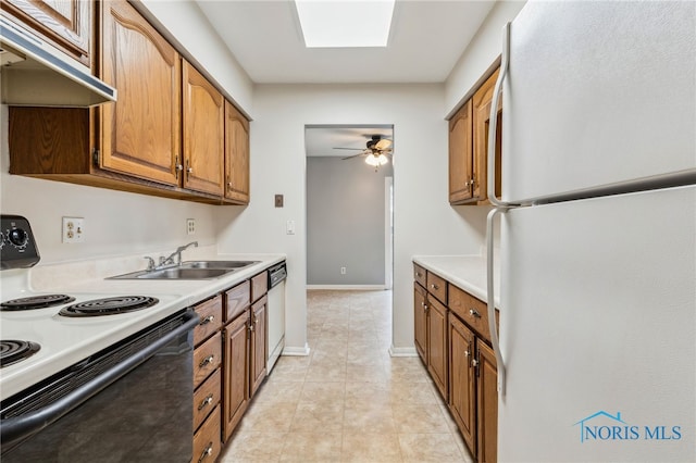 kitchen with sink, light tile patterned flooring, a skylight, ceiling fan, and white appliances