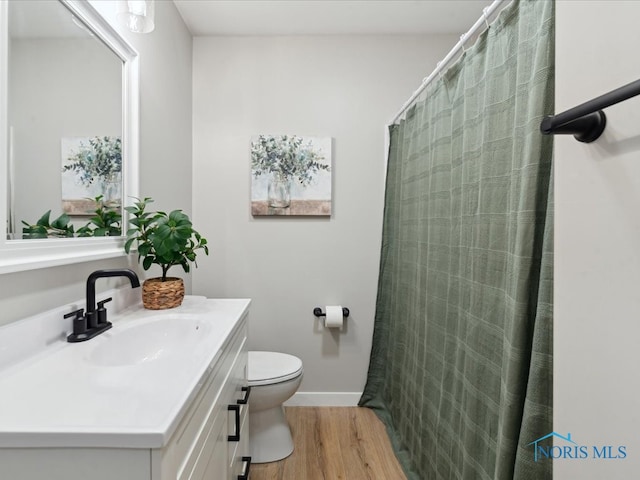 bathroom with hardwood / wood-style floors, vanity, and toilet