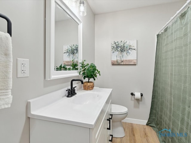 bathroom with toilet, vanity, and hardwood / wood-style flooring