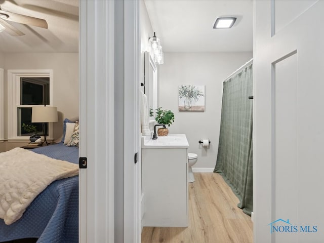 bathroom featuring hardwood / wood-style floors, vanity, ceiling fan, and toilet