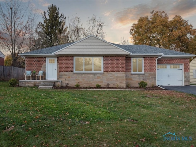 ranch-style home with a garage and a yard