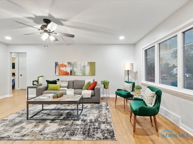 living room with light wood-type flooring and ceiling fan