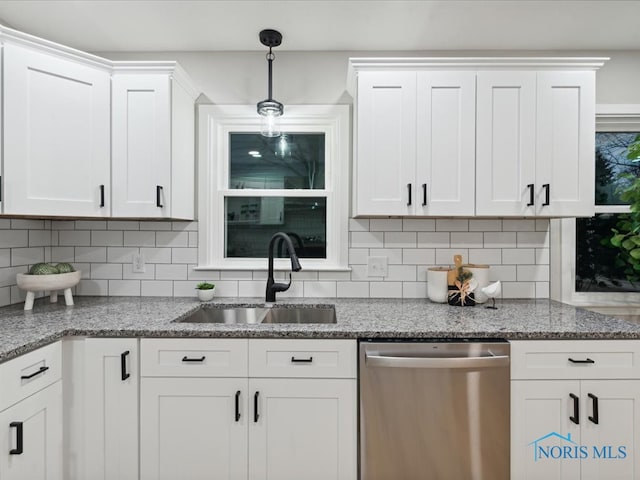 kitchen featuring stainless steel dishwasher, sink, and white cabinets