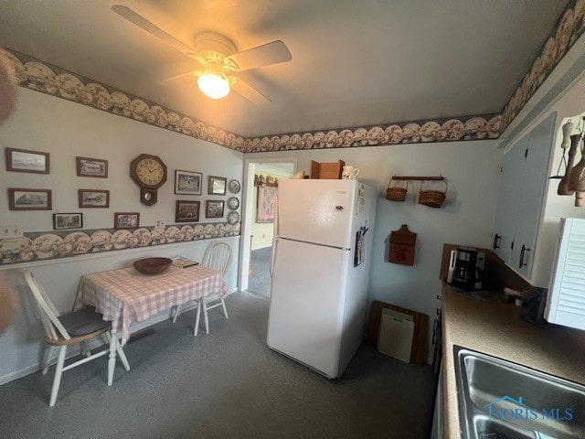 kitchen with carpet, ceiling fan, white fridge, and sink