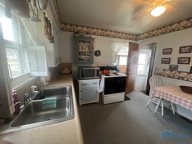 kitchen featuring white appliances, ceiling fan, and sink