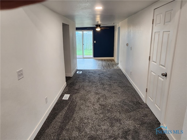 hall with dark colored carpet