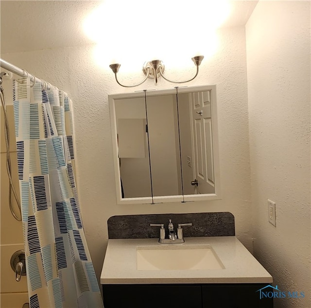 bathroom with walk in shower and vanity