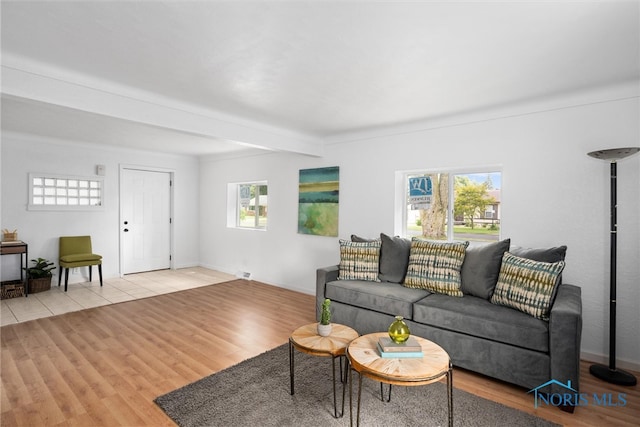 living room with beamed ceiling and light hardwood / wood-style floors