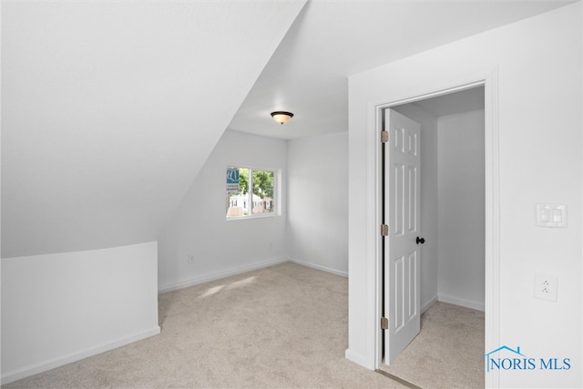 additional living space with lofted ceiling and light carpet