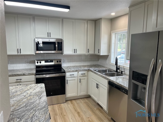 kitchen featuring appliances with stainless steel finishes, white cabinetry, and sink