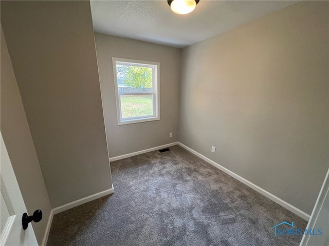 empty room featuring dark carpet