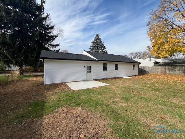 rear view of house with a patio area and a lawn