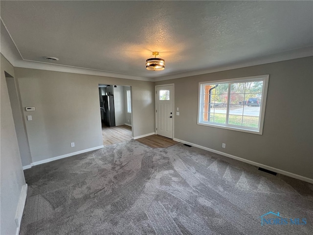 entrance foyer with carpet floors and a textured ceiling