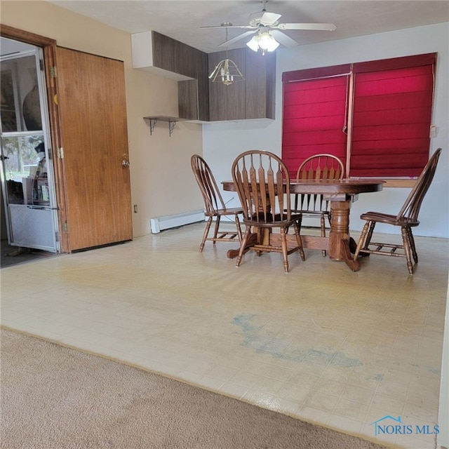 carpeted dining space with a baseboard radiator and ceiling fan