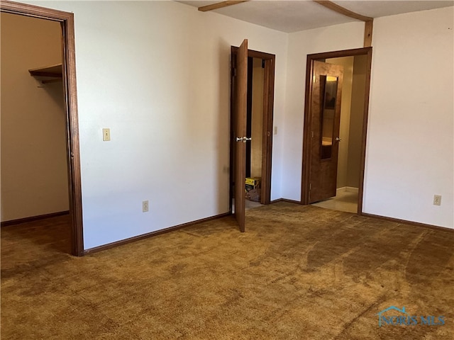 unfurnished bedroom featuring a walk in closet and carpet