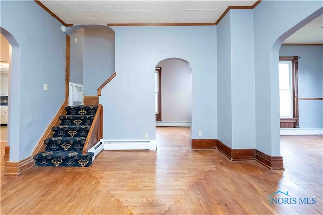 stairway featuring a baseboard heating unit and hardwood / wood-style floors