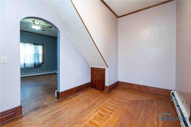 bonus room featuring a baseboard radiator, wood-type flooring, and ceiling fan