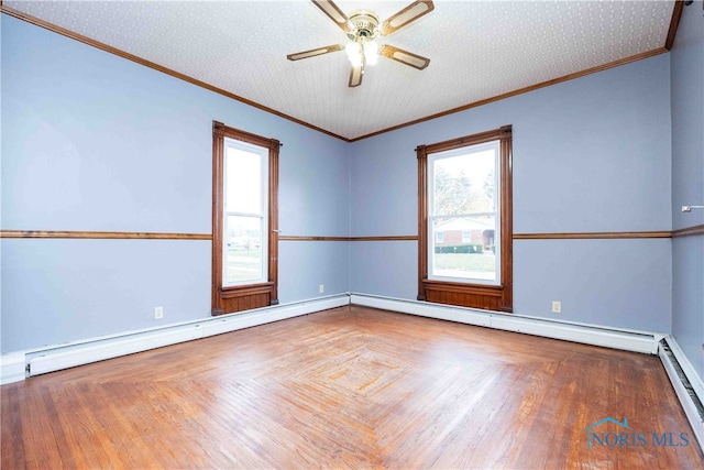 spare room featuring baseboard heating, a textured ceiling, ornamental molding, and ceiling fan