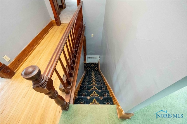 stairs featuring hardwood / wood-style floors