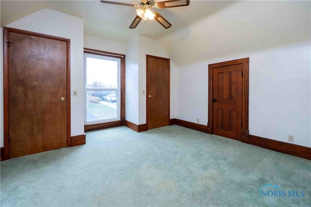 unfurnished bedroom featuring ceiling fan, light carpet, and vaulted ceiling