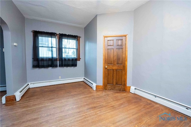 spare room with a baseboard radiator and light wood-type flooring