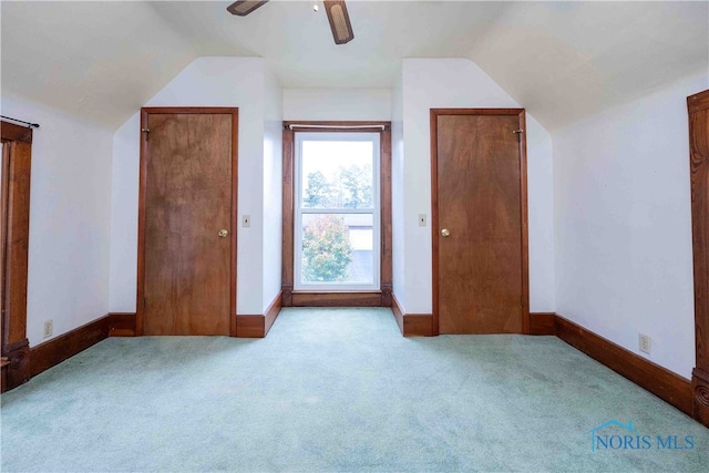 additional living space with ceiling fan, light colored carpet, and vaulted ceiling