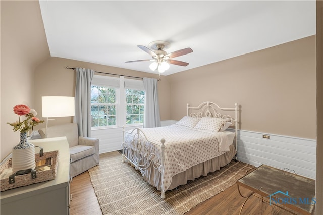 bedroom with ceiling fan, light hardwood / wood-style flooring, and lofted ceiling