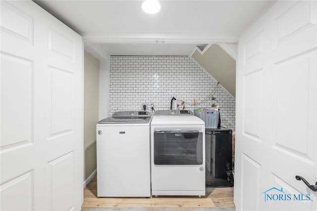 washroom featuring light hardwood / wood-style flooring and washing machine and clothes dryer