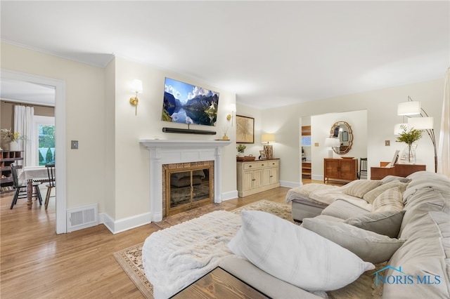 living room with light hardwood / wood-style floors and ornamental molding