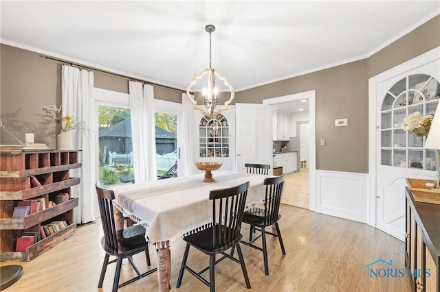 dining space featuring ornamental molding, a chandelier, and light wood-type flooring