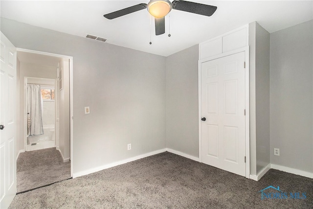 unfurnished bedroom with ceiling fan and dark carpet