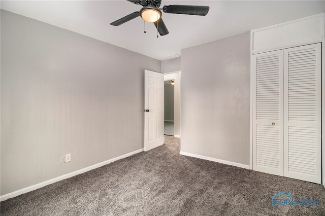 unfurnished bedroom featuring dark carpet, a closet, and ceiling fan