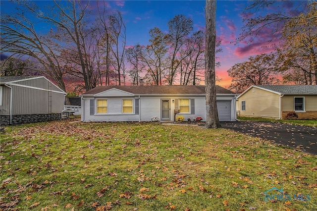 view of front of house featuring a garage and a lawn