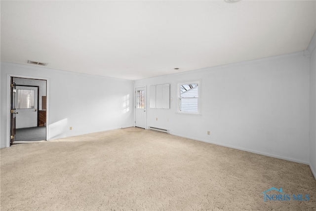 spare room with carpet flooring and a baseboard heating unit