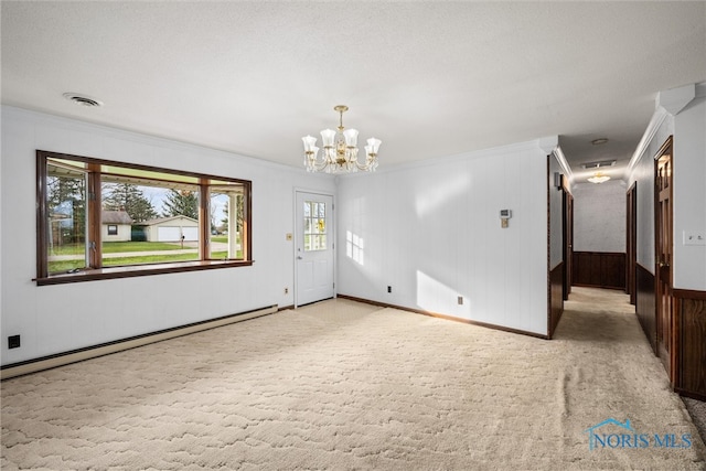 unfurnished room featuring light carpet, a baseboard heating unit, ornamental molding, a textured ceiling, and a chandelier