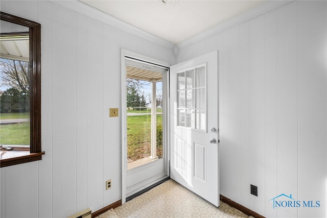 doorway to outside with ornamental molding and wooden walls