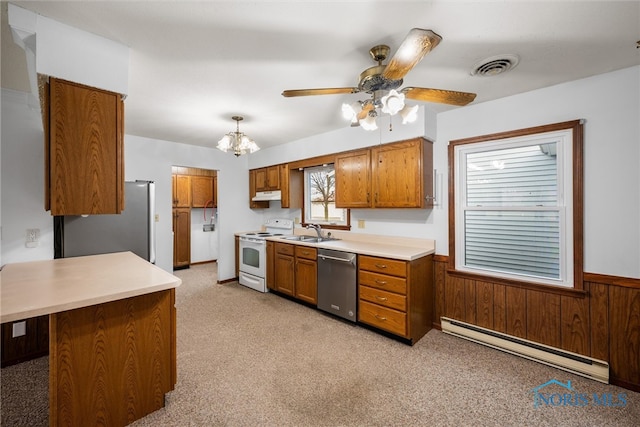 kitchen with sink, a baseboard heating unit, light colored carpet, wooden walls, and appliances with stainless steel finishes