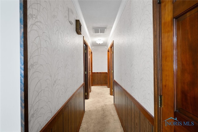 hallway featuring light colored carpet and crown molding