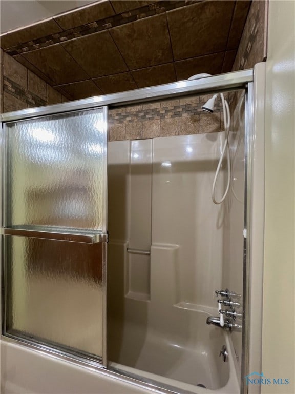 bathroom with bath / shower combo with glass door