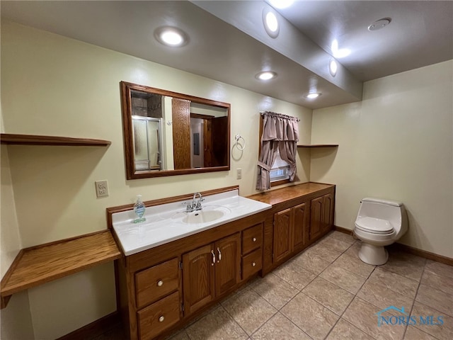 bathroom featuring tile patterned floors, vanity, a shower with shower door, and toilet