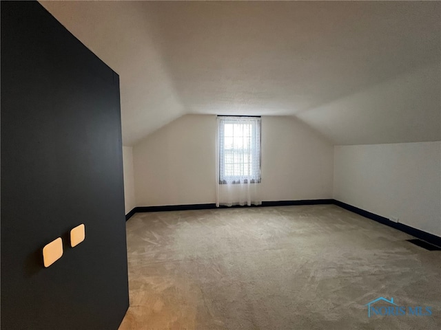 bonus room featuring light carpet and vaulted ceiling