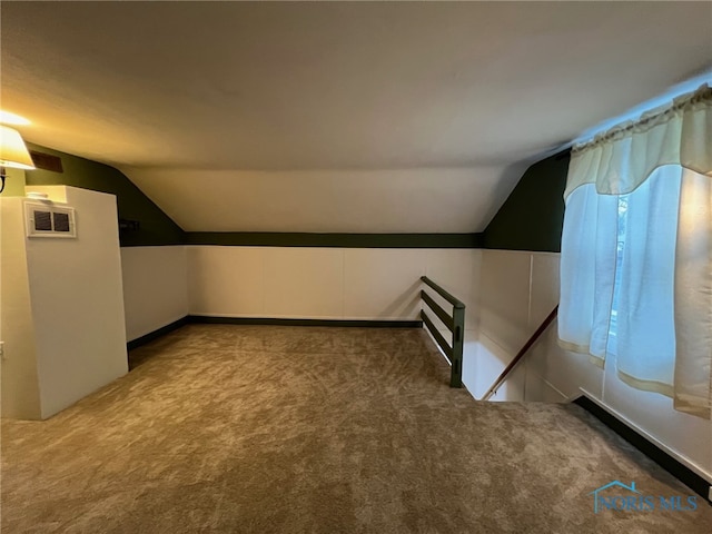 additional living space featuring carpet flooring and vaulted ceiling