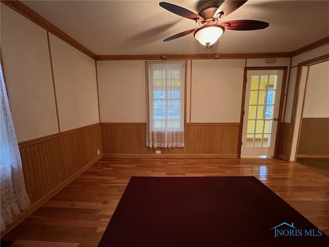 unfurnished room featuring hardwood / wood-style flooring, ceiling fan, and crown molding