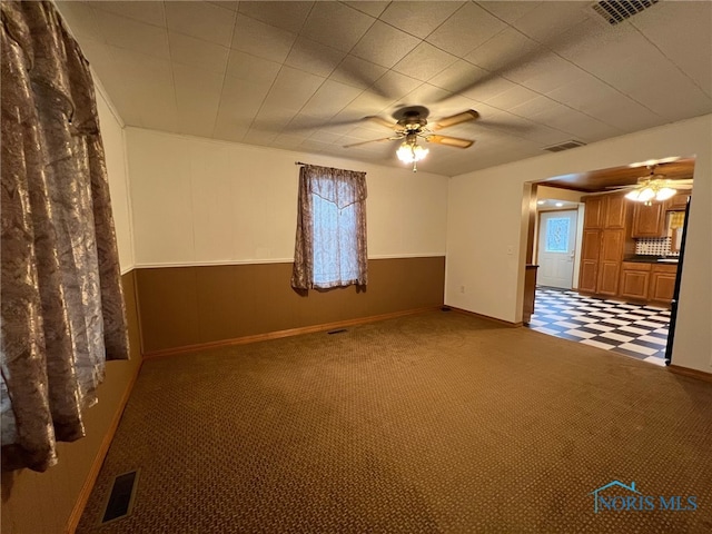 carpeted spare room featuring ceiling fan